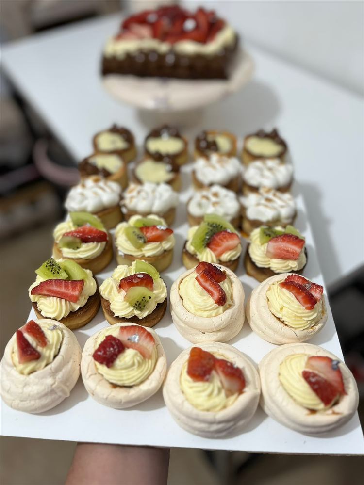 Mesa dulce con torta de frutillas y bandeja de mini tartas