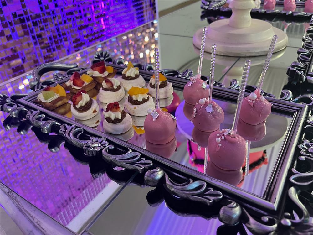 Mesa dulce con mini postres y cake pops rosas