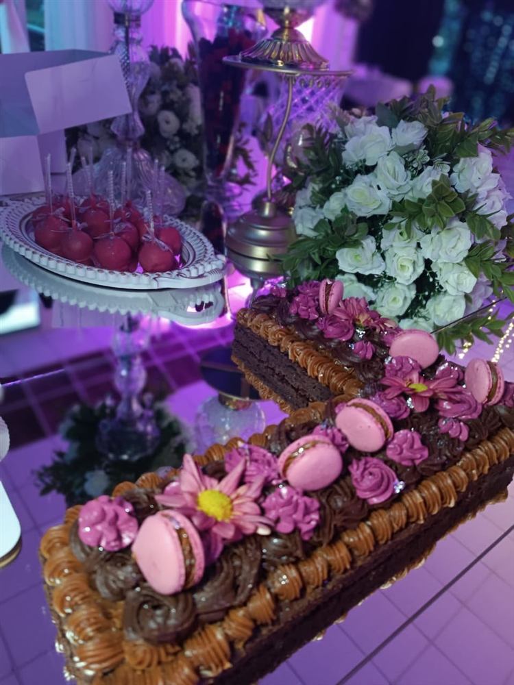 Mesa dulce con torta de chocolate, macarons y flores
